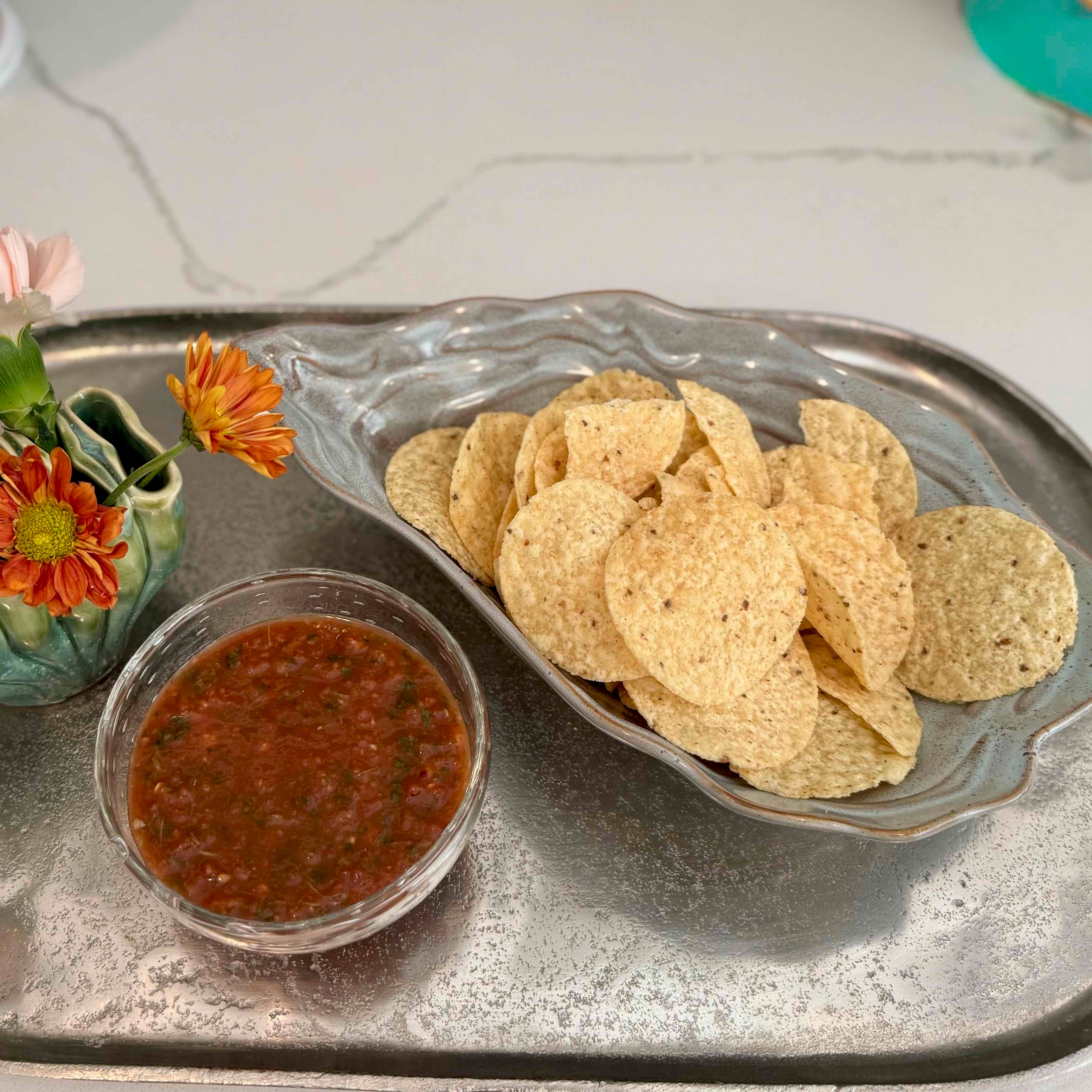 Tray with tortilla chips and salsa on a marble surface