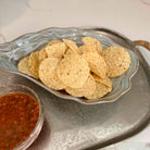 Tortilla chips on a decorative plate with a side of salsa.