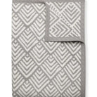 Gray and white geometric patterned blanket on a white background