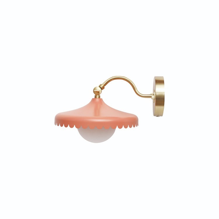 Wall-mounted lamp with pink shade and gold arm on a white background