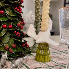 Decorative Christmas scene with angel, trees, and animals on a tablecloth.