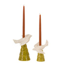 Two bird-shaped candle holders with red candles on a white background