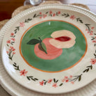Decorative plate with a peach design on a floral border
