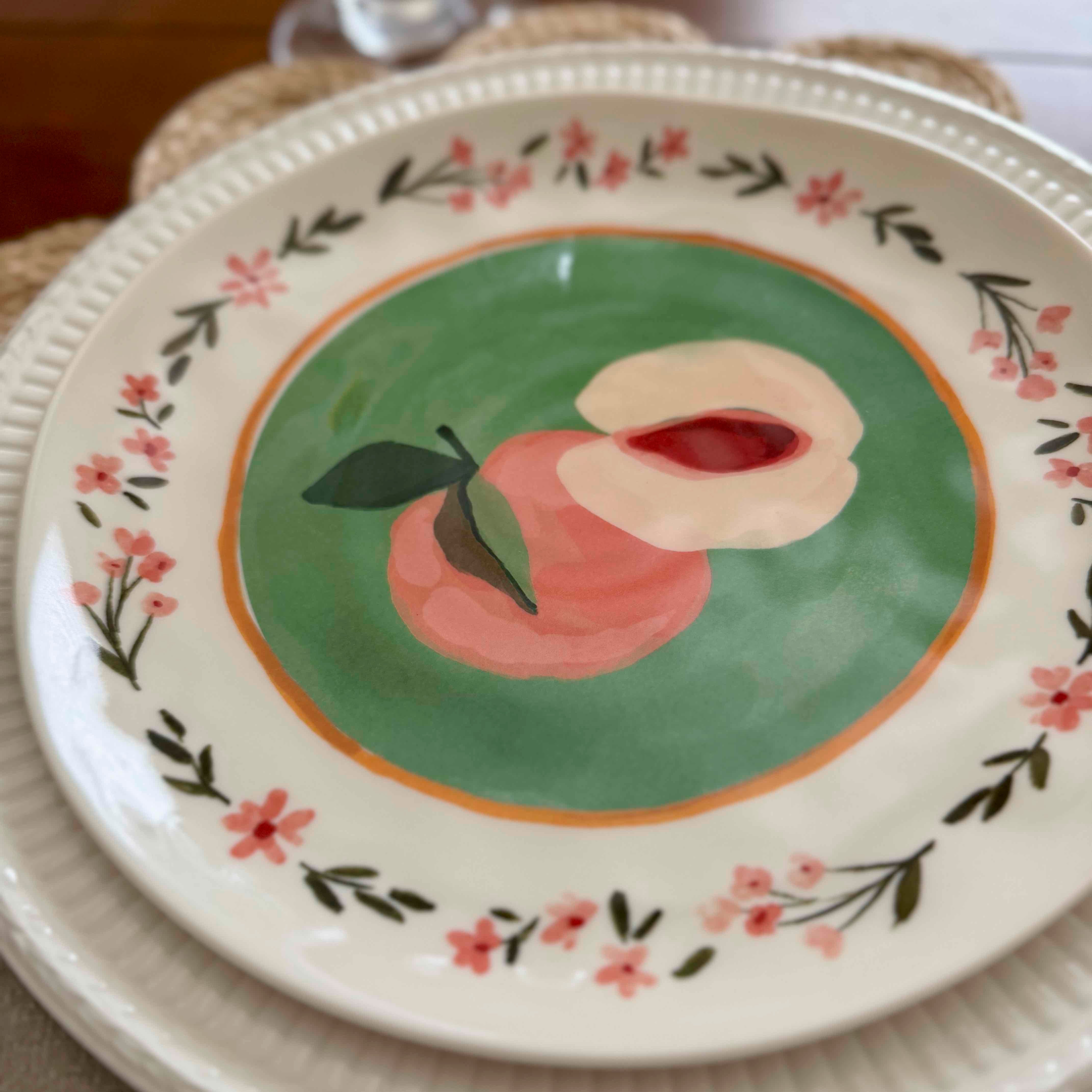 Decorative plate with a peach design on a floral border