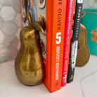 Three cookbooks stacked with decorative gourds on a surface