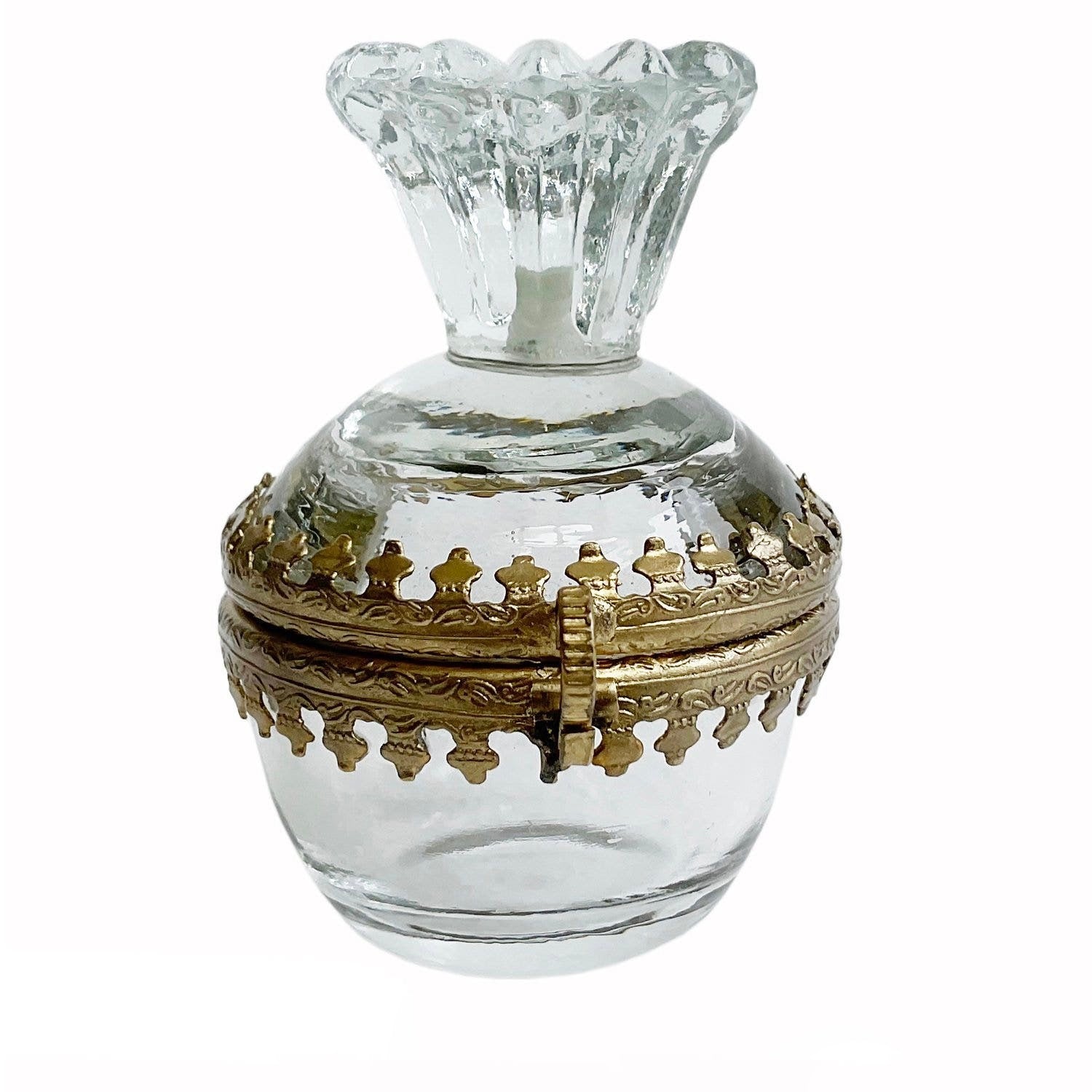 Clear glass container with gold decorative lid on a white background
