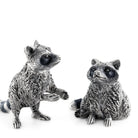 Two silver raccoon figurines on a white background