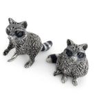Two silver raccoon figurines on a white background