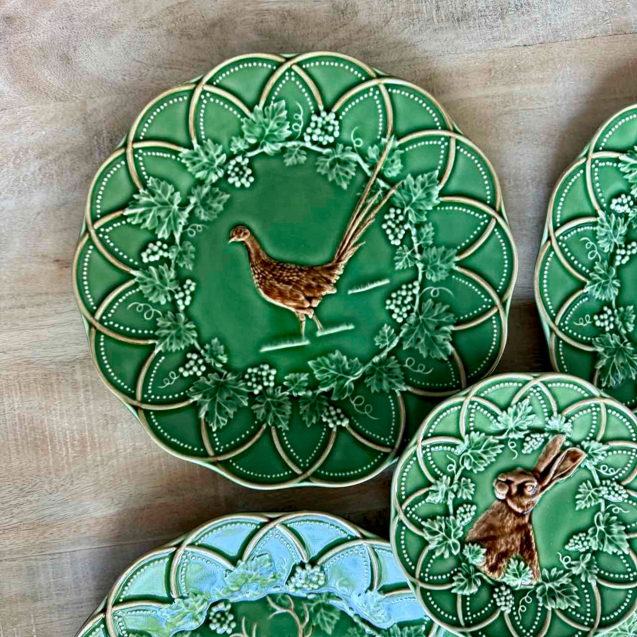 Decorative green plates with animal illustrations on a wooden surface
