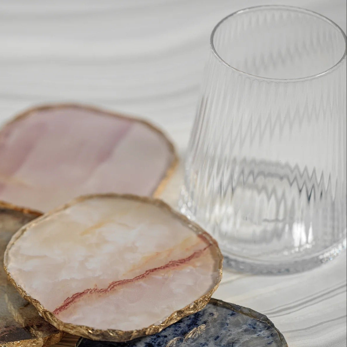 Set of decorative coasters with a glass on a light background