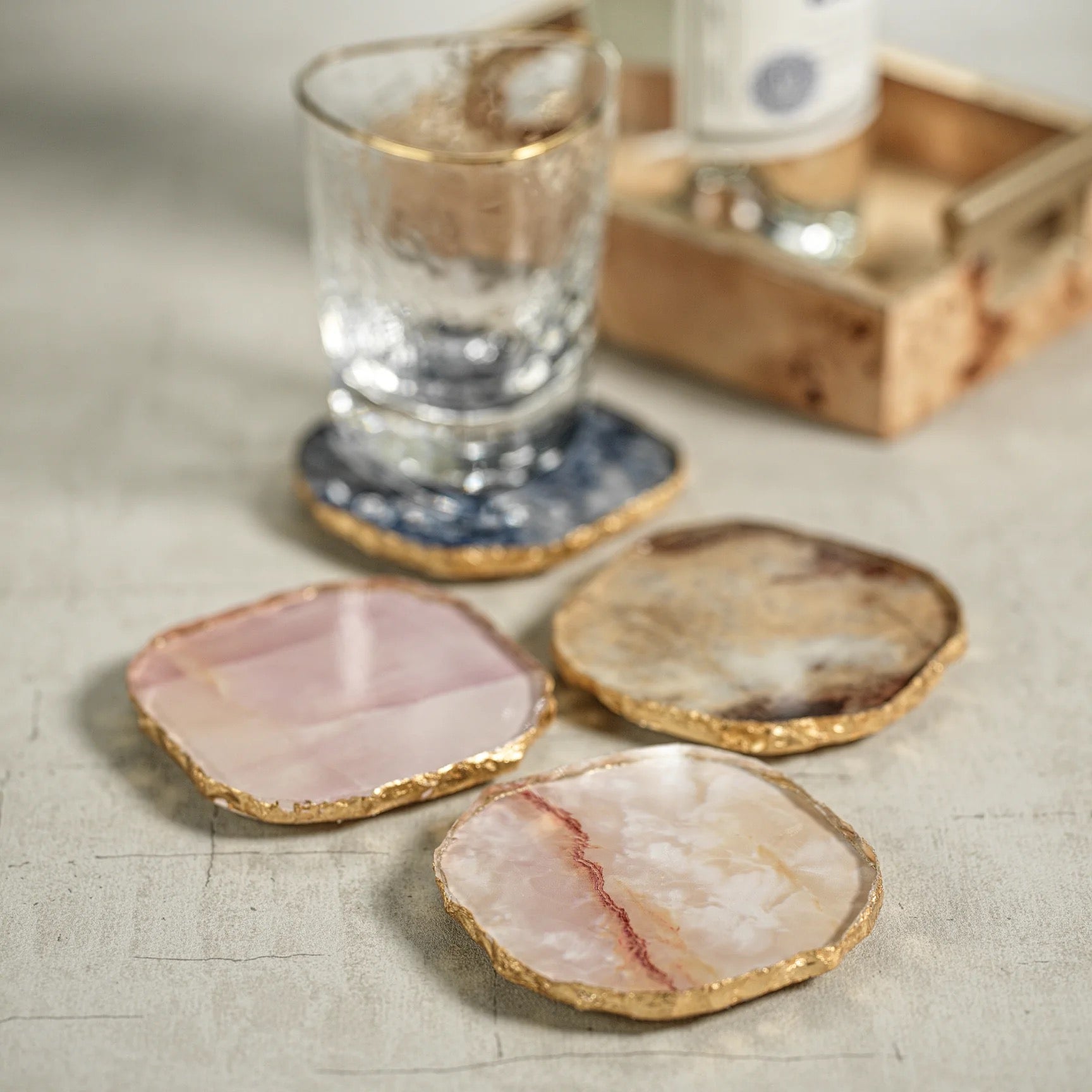 Set of decorative coasters with a glass of water on a textured surface