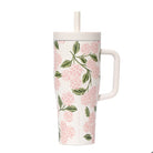 Floral-patterned mug with a handle and straw on a white background