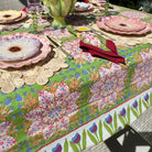 Colorful floral-patterned tablecloth on a table with cutlery and plates.