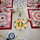 Decorative table setting with floral plates and cards on a white surface.