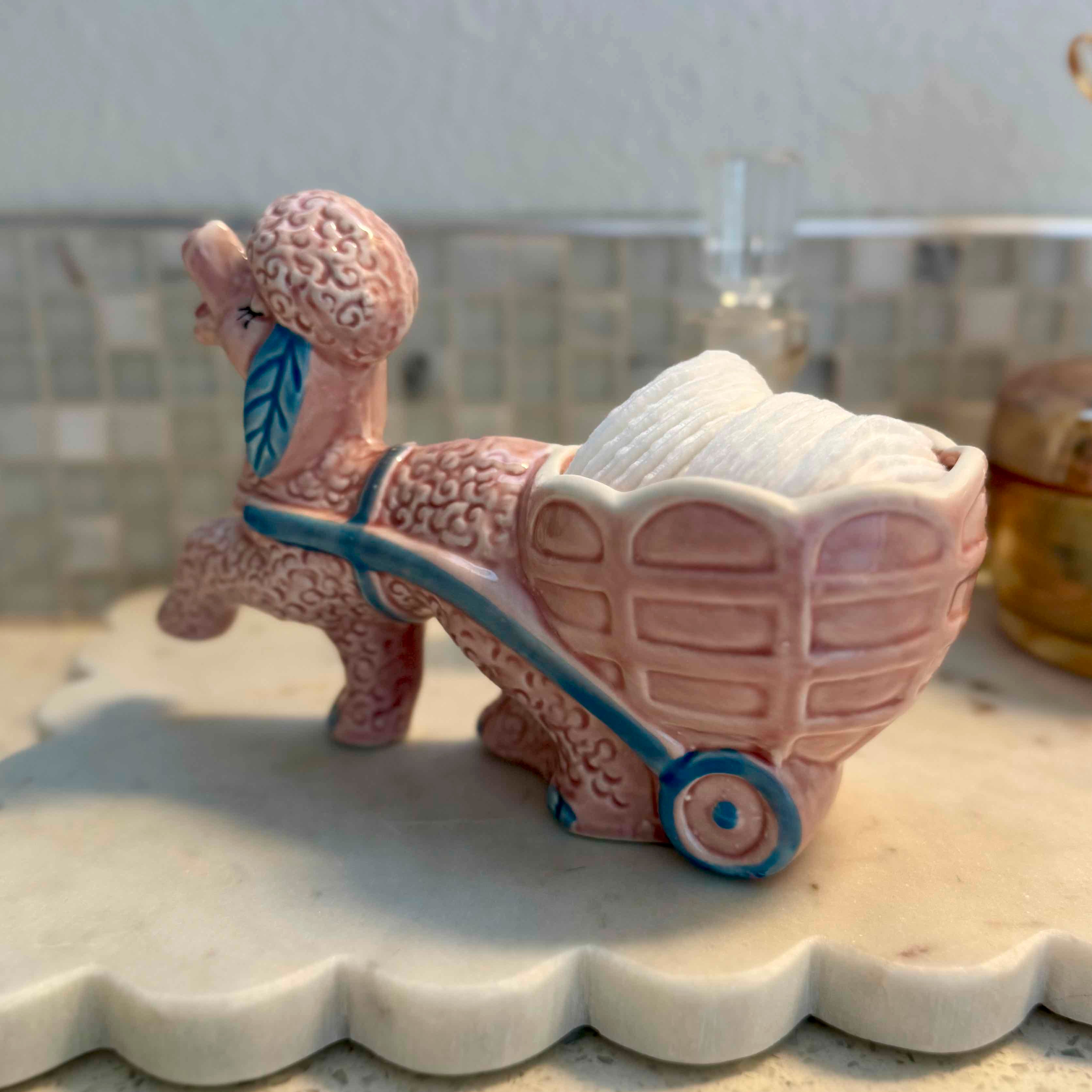 Ceramic dog pulling a cart on a tiled surface