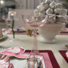 Decorative table setting with a glass, place card, and candle.