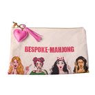 A rectangular beige fabric pouch with a gold zipper, featuring a pink heart-shaped tassel charm, the text 'BESPOKE+MAHJONG' in pink, and cartoon illustrations of four women at the bottom.
