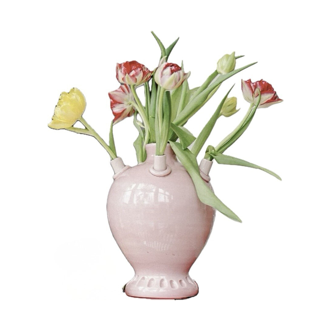 Pink ceramic vase with tulips on a white background