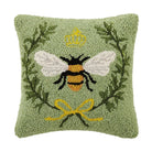 Decorative pillow with a bee design on a green background