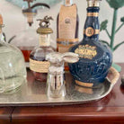 Bottle of Crown Royal 21-year-old whisky on a tray with other bottles in the background.