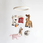 Children's mobile with farm animal toys hanging from a ceiling ring on a white background
