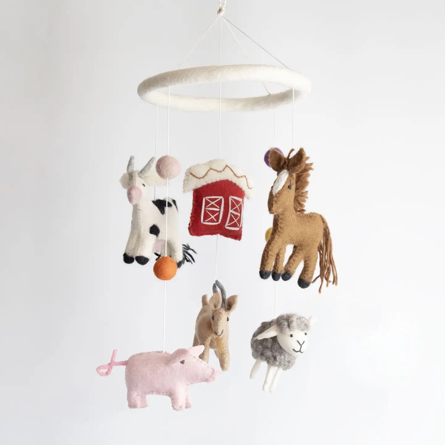 Children's mobile with farm animal toys hanging from a ceiling ring on a white background