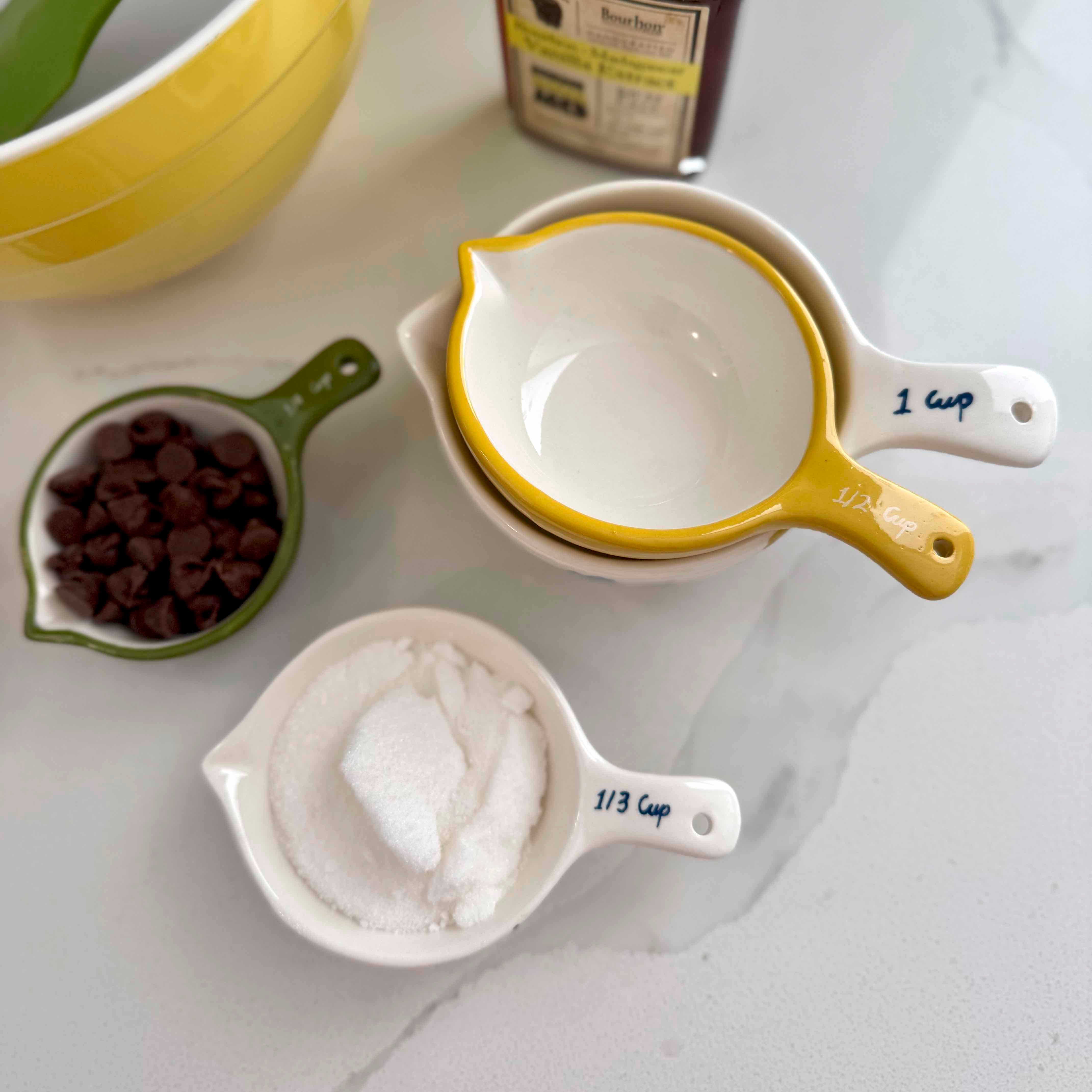 Measuring cups with ingredients on a white surface