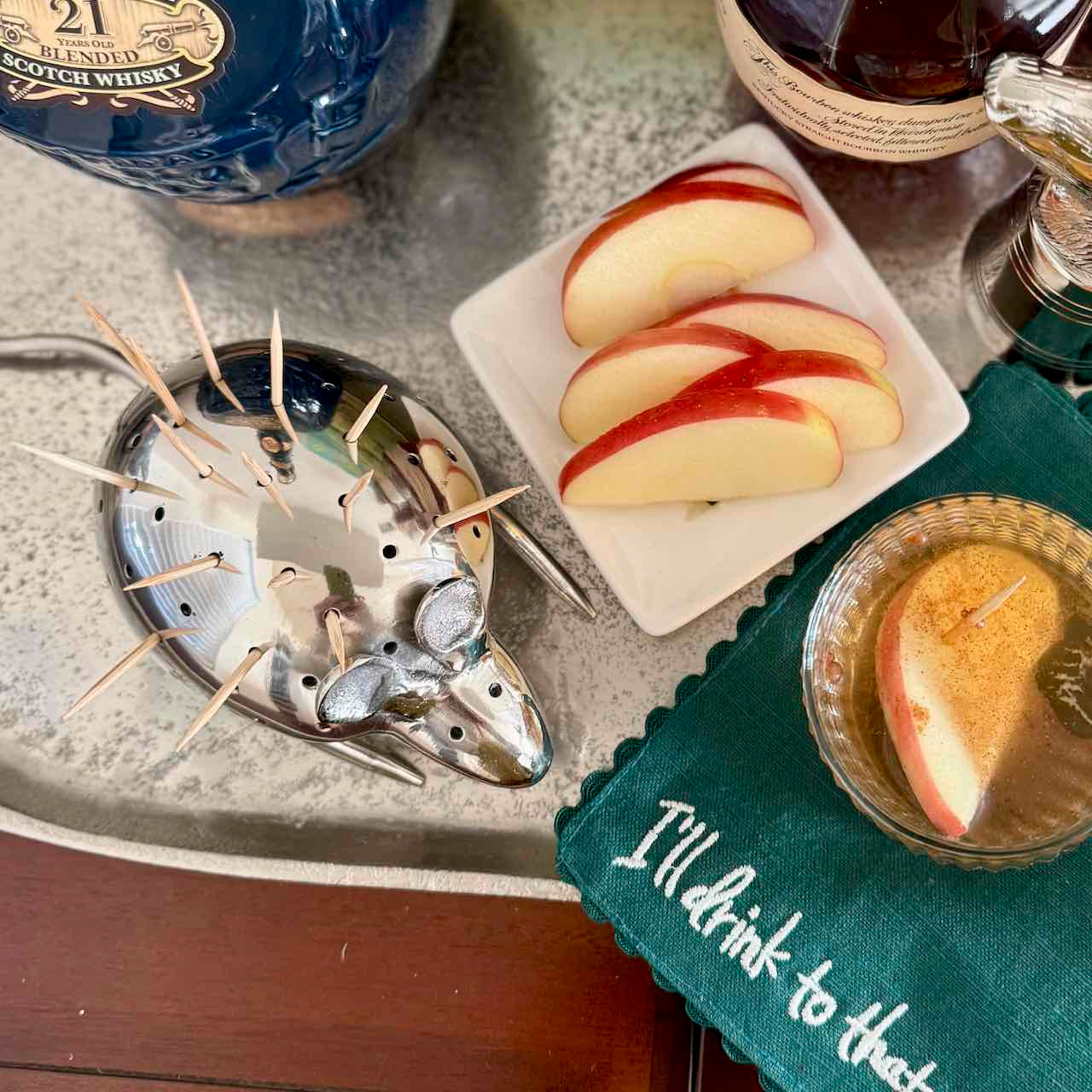 Apples on a tray with a bottle of Johnnie Walker Blue Label whisky and a glass of whisky.