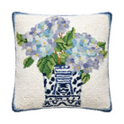 Decorative pillow with floral design and blue vase on a white background