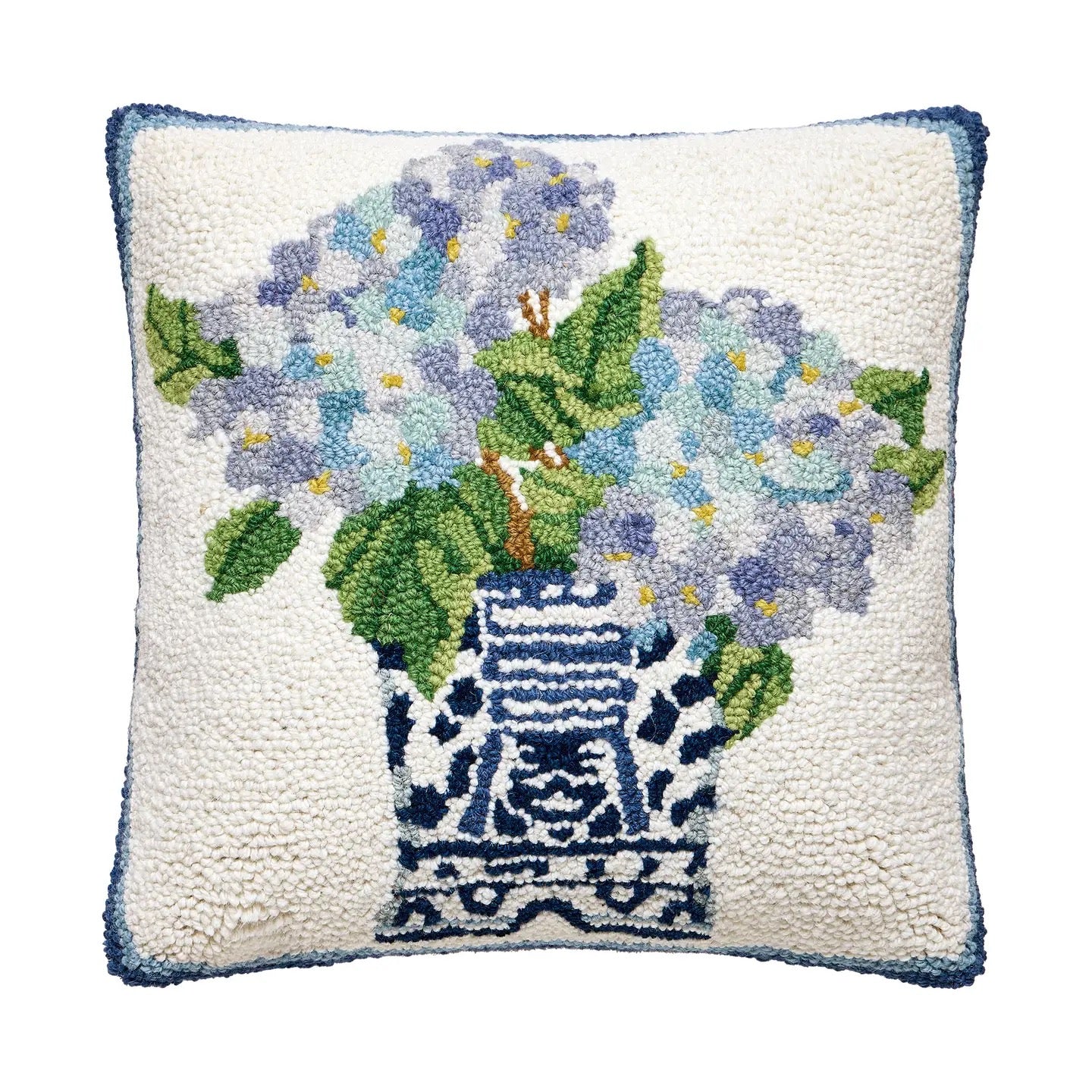 Decorative pillow with floral design and blue vase on a white background