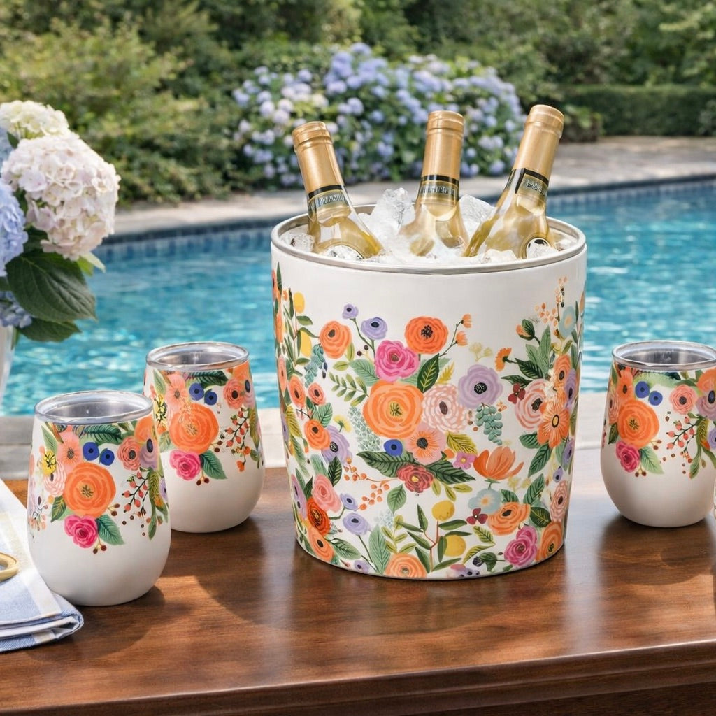 Floral-patterned ice bucket and tumblers on a table by a pool