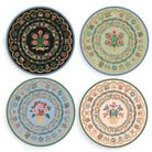 Four decorative plates with floral and geometric patterns on a white background