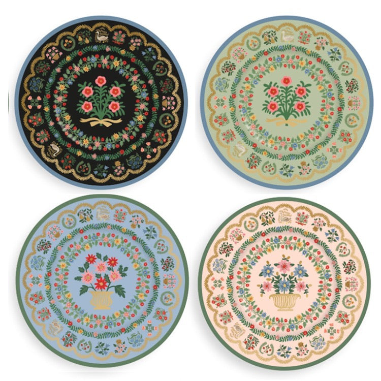 Four decorative plates with floral and geometric patterns on a white background