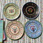 Four decorative plates with floral patterns on a matching tablecloth.