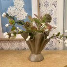 Decorative vase with artificial flowers on a wooden surface