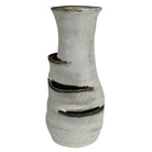 A handmade ceramic vase with a textured, speckled off-white glaze and dark brown glazed accents along three horizontal ridges, set against a plain white background.