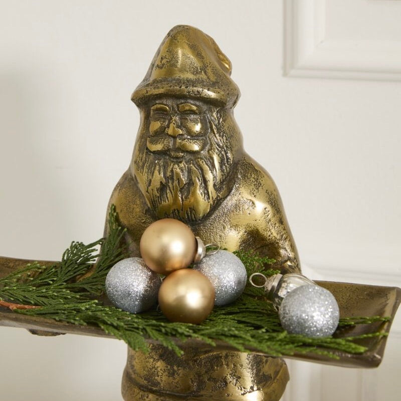 Bronze gnome figurine with Christmas ornaments on a white background
