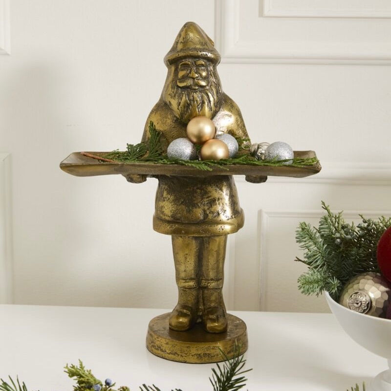 Decorative figure of a gnome holding ornaments on a white surface with a neutral background