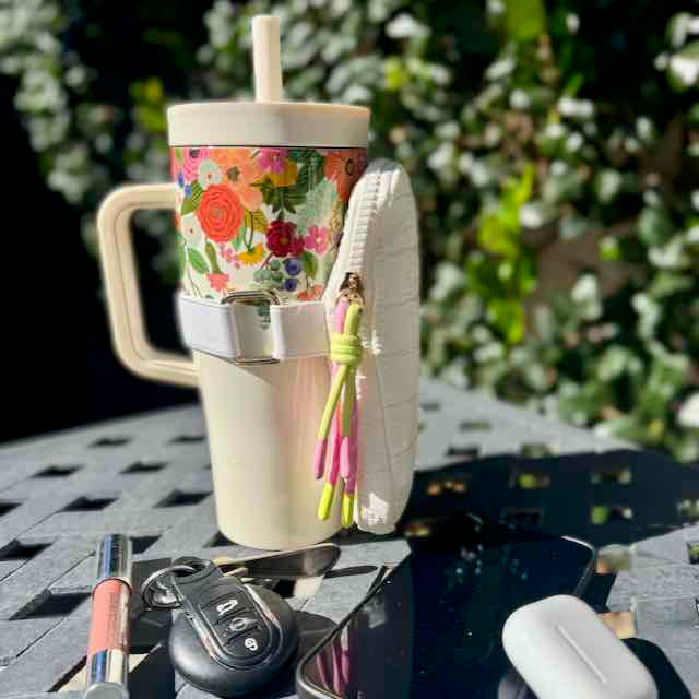 Floral-patterned tumbler with a white base on a table outdoors