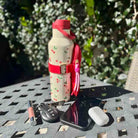 Water bottle with cherry design on a table outdoors