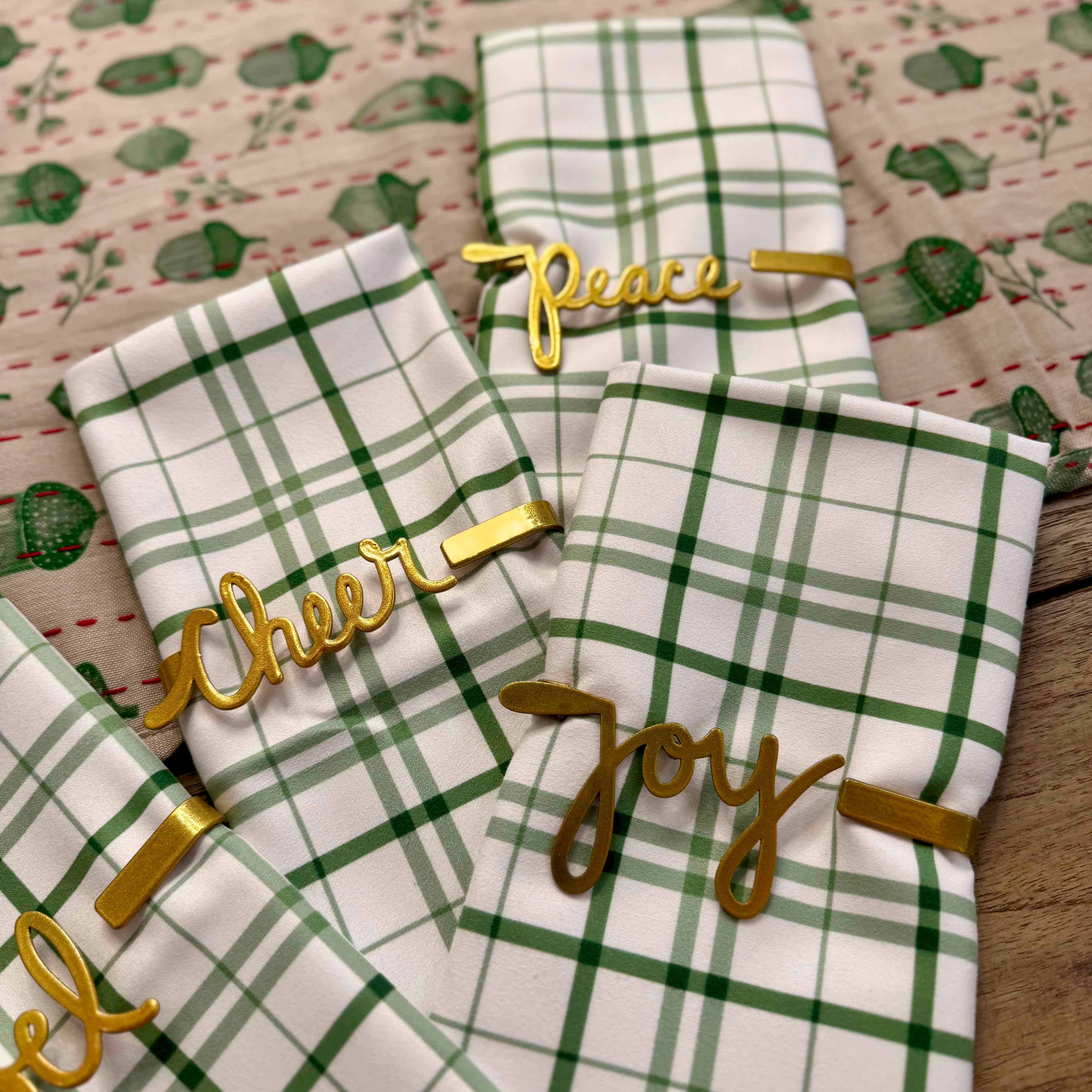 Green and white plaid towels with gold text on a patterned background