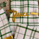 Green and white plaid fabric with gold 'peace' embellishment