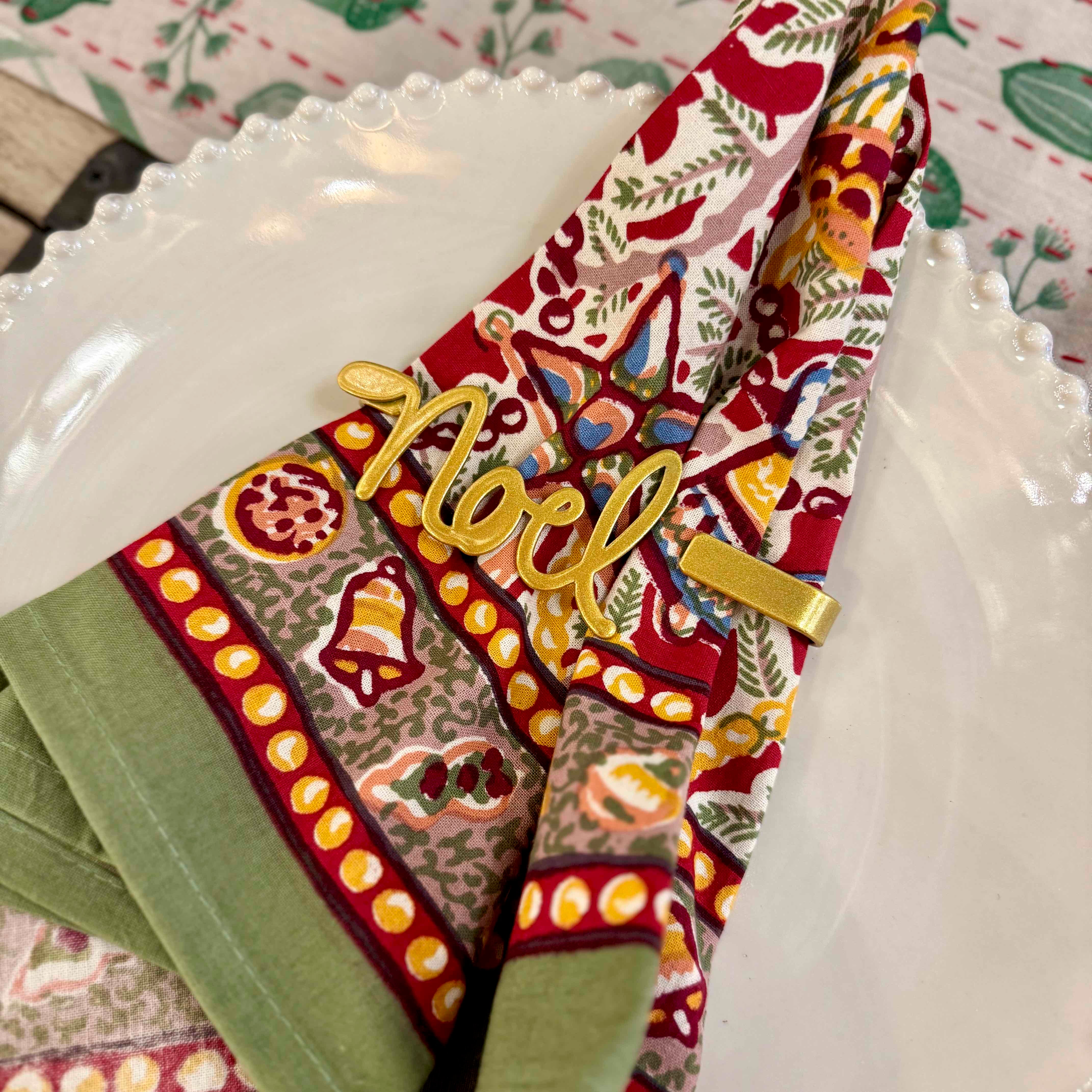 Decorative napkin with 'Noel' text on a white plate