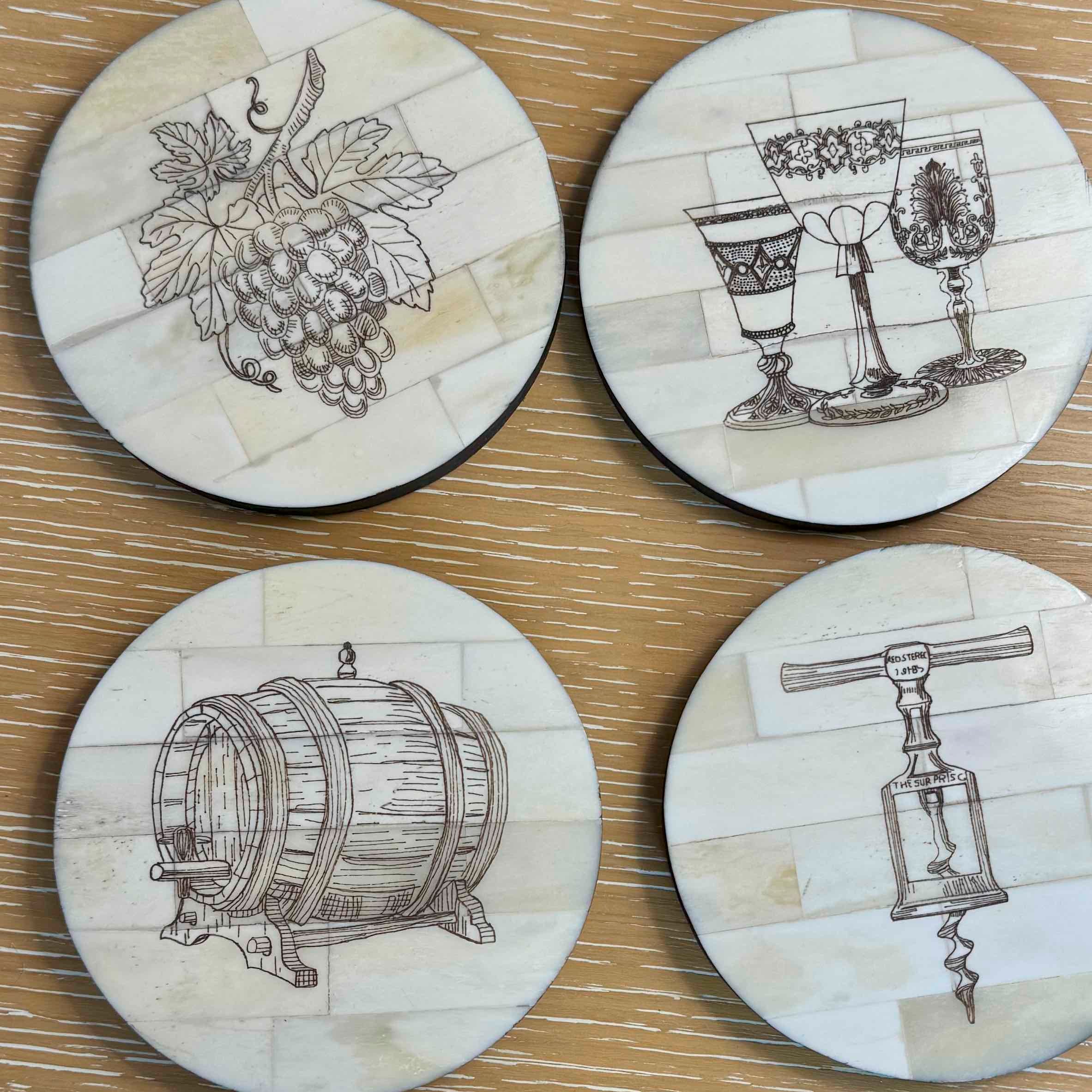 Four round coasters with wine-themed illustrations on a wooden surface.