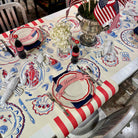 Dining table set with American-themed decor, including plates, napkins, and a centerpiece.