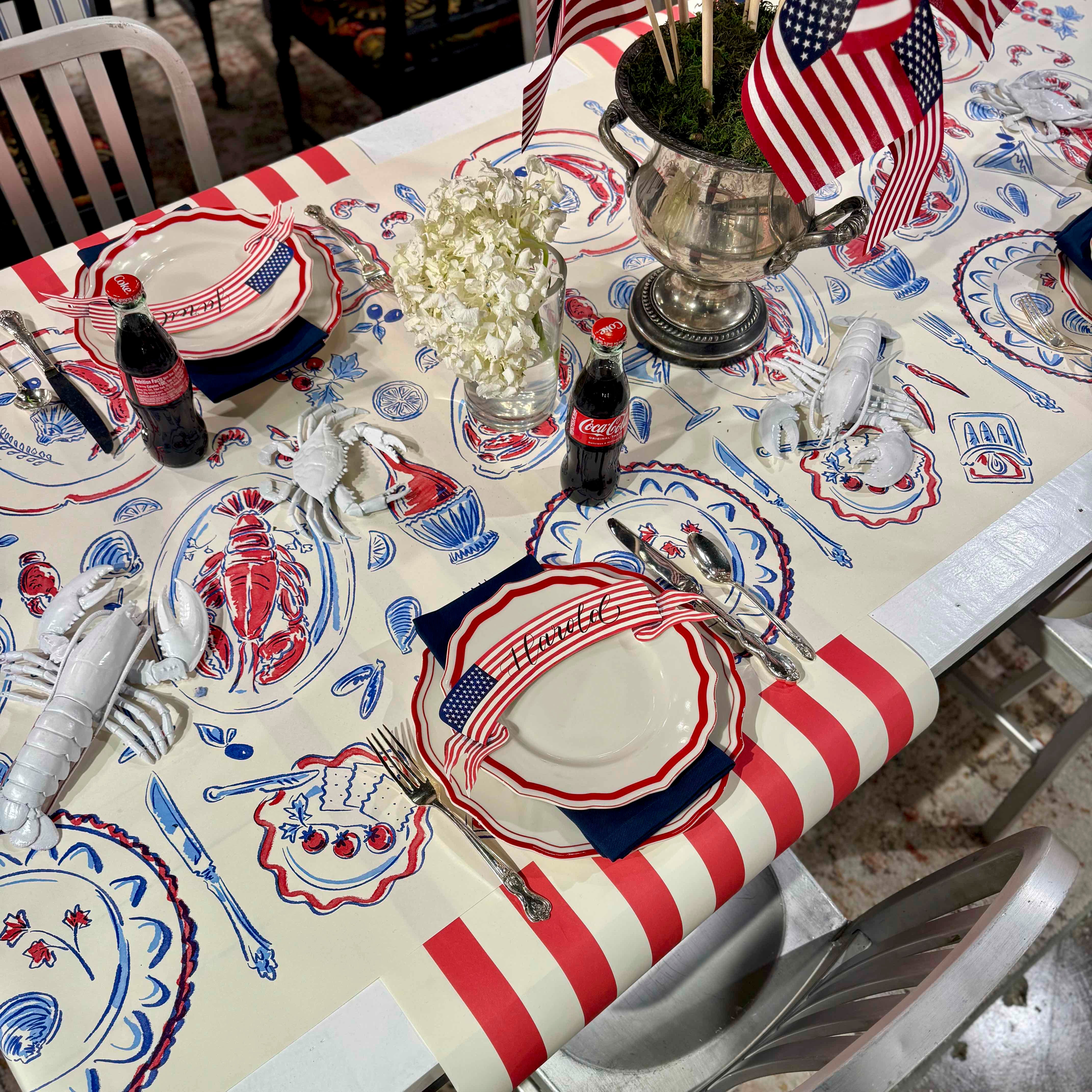 Dining table set with American-themed decor, including plates, napkins, and a centerpiece.