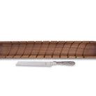Wooden rolling pin with a silver knife on a white background