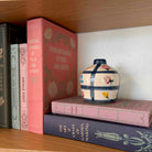 Books and a decorative vase on a wooden shelf