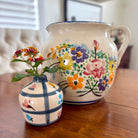 Two ceramic vases with floral designs on a wooden surface