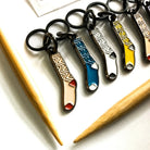 Set of colorful keychains on a white surface with a wooden object in the background